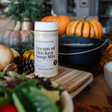 Container of Cream of Chicken Soup Mix on a table with pumpkins and other fall decorations.