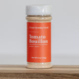 Container of Tomato Bouillon on a wooden surface with a white background