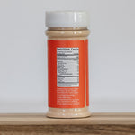 Jar of peanut butter with a red label on a wooden surface and white background