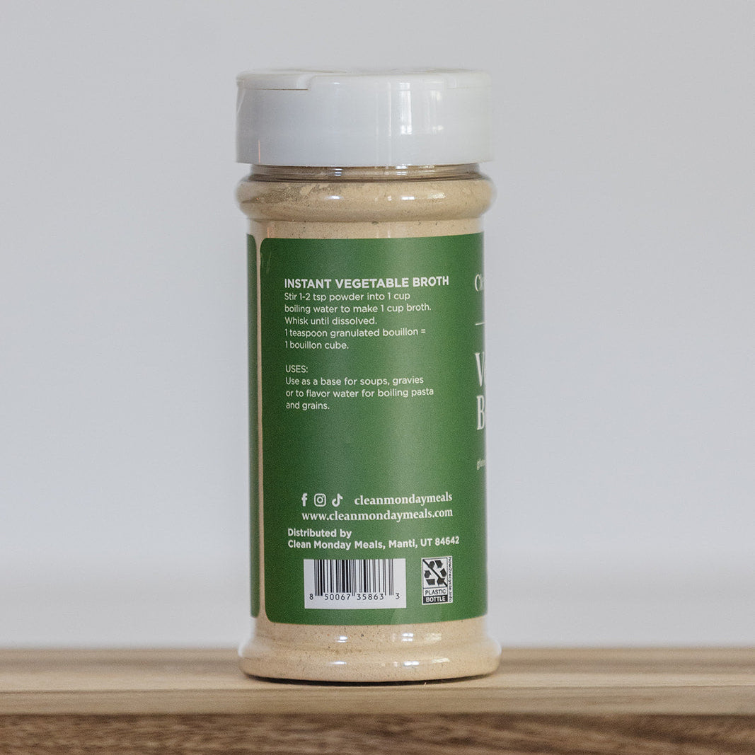 Jar of instant vegetable broth on a wooden surface with a white background