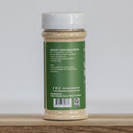 Jar of instant vegetable broth on a wooden surface with a white background