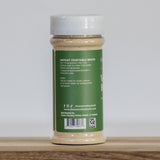 Jar of instant vegetable broth on a wooden surface with a white background