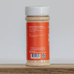Jar of instant tomato broth on a wooden surface with a white background
