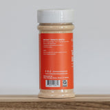 Jar of instant tomato broth on a wooden surface with a white background