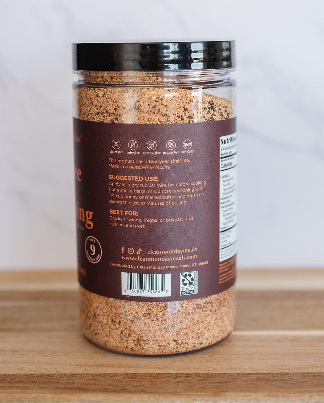 Jar of ground spices on a wooden surface with a white background