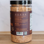 Jar of ground spices on a wooden surface with a white background