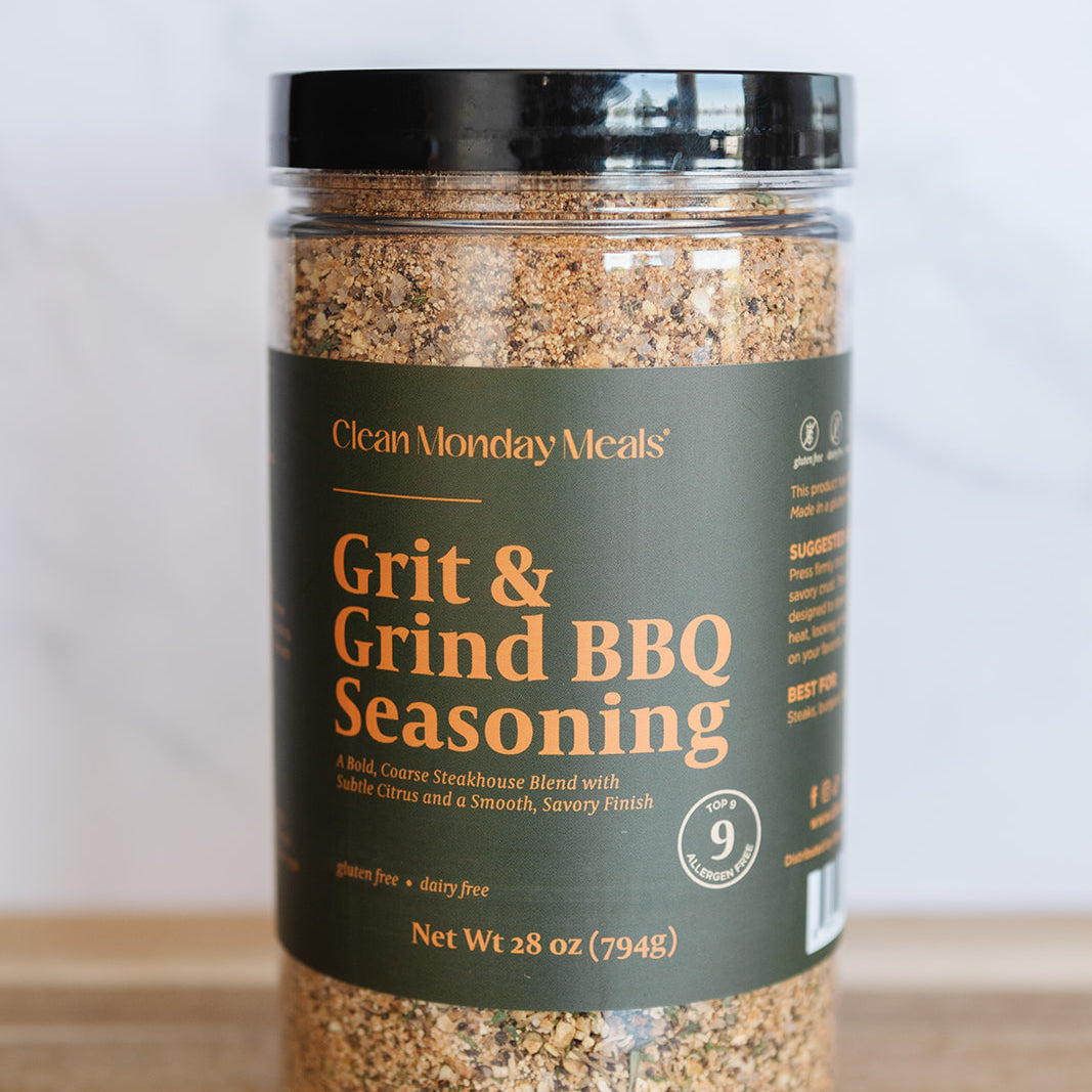 Jar of Grit & Grind BBQ Seasoning on a wooden surface with a white background