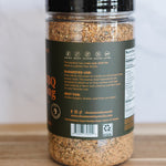 Spice jar with a label on a wooden surface and white background