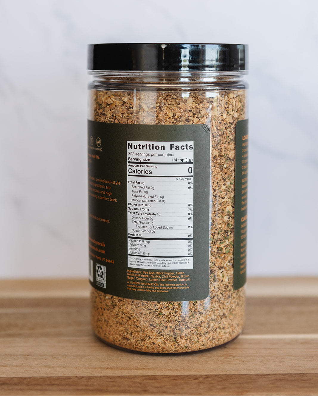 Jar of ground spice with nutrition label on a wooden surface and white background