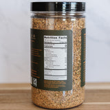 Jar of ground spice with nutrition label on a wooden surface and white background