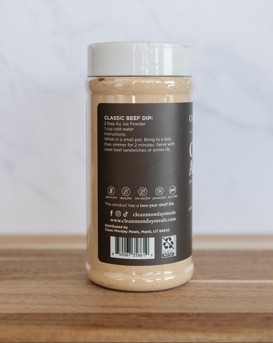 A jar of Diamond's Gourmet Classic Beef Dip, showing the back label, placed on a wooden surface against a light marble background.