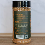 Spice jar with black lid and label on a wooden surface