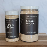 Two jars of Clean Au Jus gluten-free and dairy-free flour mix by Clean Monday Meals, displayed on a wooden cutting board against a white marble background.
