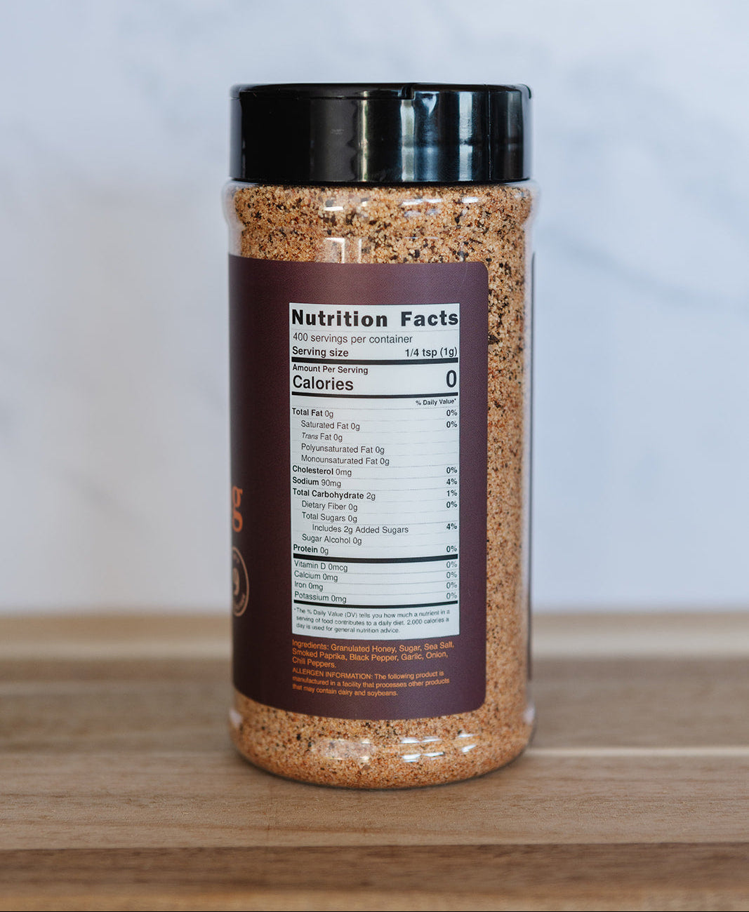 Spice jar with a label on a wooden surface and light gray background