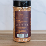 Spice jar with a black lid on a wooden surface and light gray background