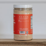 Jar of Clean Monday Meals tomato bouillon on a wooden surface, white background. 