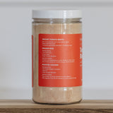 Jar of instant tomato broth on a wooden surface with a white background
