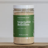 Jar of Vegetable Bouillon with a green label on a wooden surface.