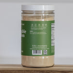 Jar of vegetable stock on a wooden surface with a white background
