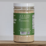 Jar of vegetable stock on a wooden surface with a white background