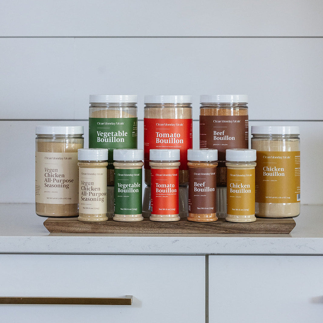 Collection of bouillon containers on a wooden board against a white kitchen cabinet background