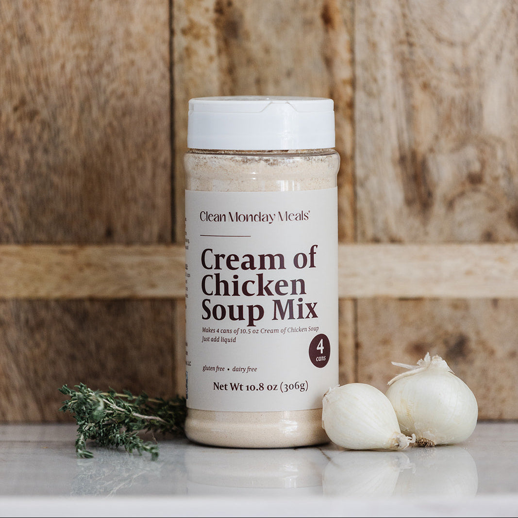 Jar of 'Cream of Chicken Soup Mix' on a wooden surface with garlic and herbs.