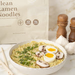 Bowl of ramen noodles with a package of clean ramen noodles in the background.