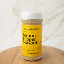 Bottle of Lemon Pepper Seasoning on a wooden surface with a white background